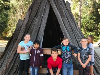 Westside students pose in front of a teepee