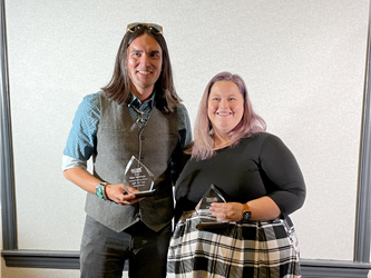 man and woman smiling, holding awards