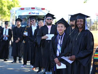 graduates celebrating and smiling at their graduation ceremony
