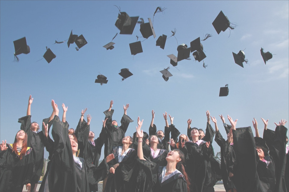 high school grads throwing hats in air