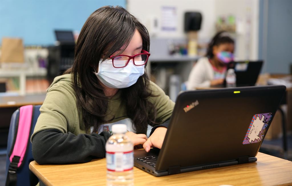 girl with mask using laptop